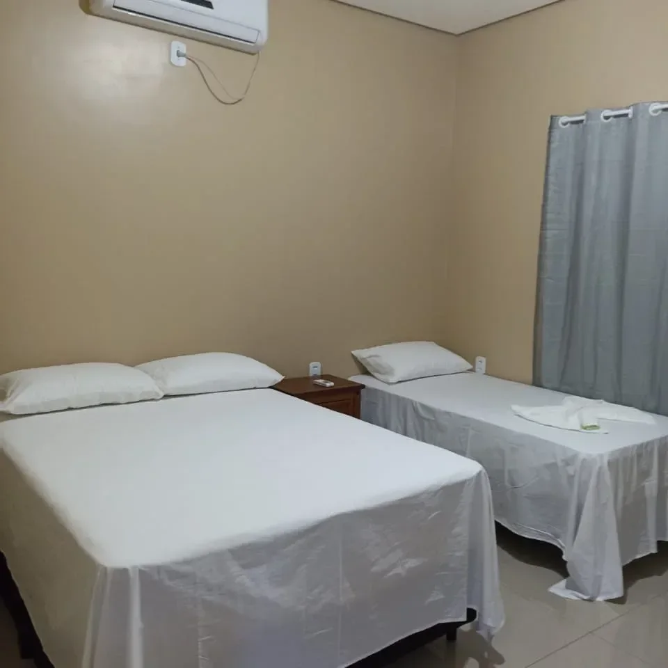 Apartamento com cama de casal, cama de solteiro e ar-condicionado.